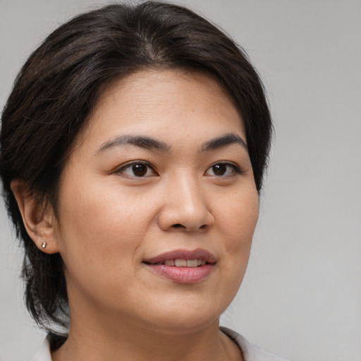 Joyful asian young-adult female with medium  brown hair and brown eyes