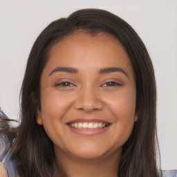 Joyful latino young-adult female with long  brown hair and brown eyes