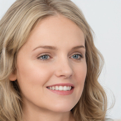 Joyful white young-adult female with long  blond hair and blue eyes