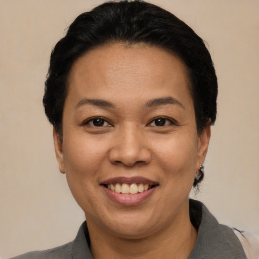 Joyful latino adult female with short  brown hair and brown eyes