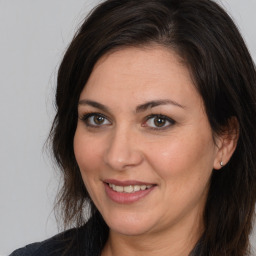 Joyful white adult female with long  brown hair and brown eyes