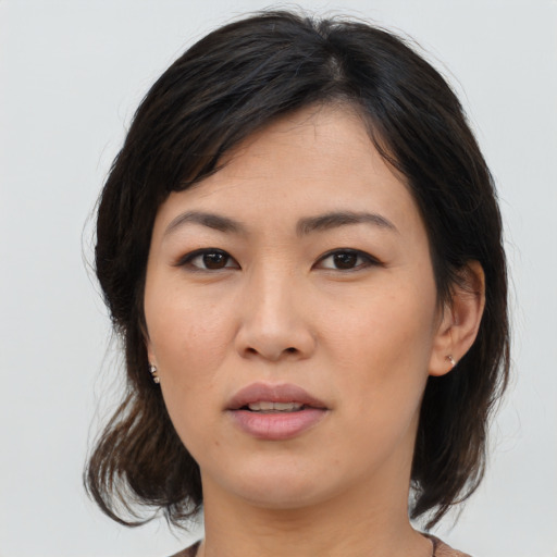 Joyful asian young-adult female with medium  brown hair and brown eyes