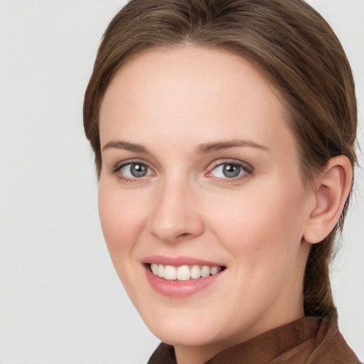 Joyful white young-adult female with long  brown hair and grey eyes