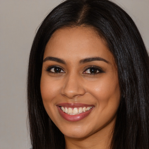 Joyful latino young-adult female with long  black hair and brown eyes