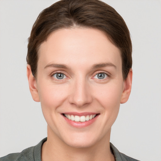 Joyful white young-adult female with short  brown hair and grey eyes