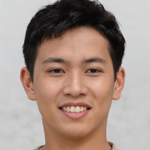 Joyful asian young-adult male with short  brown hair and brown eyes