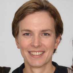 Joyful white adult female with medium  brown hair and grey eyes