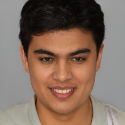 Joyful latino young-adult male with short  brown hair and brown eyes