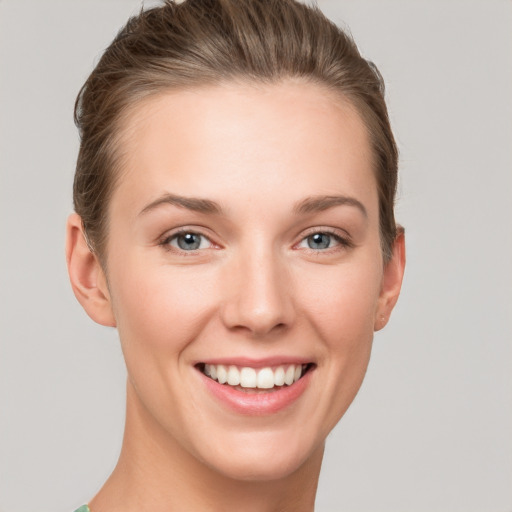 Joyful white young-adult female with short  brown hair and grey eyes