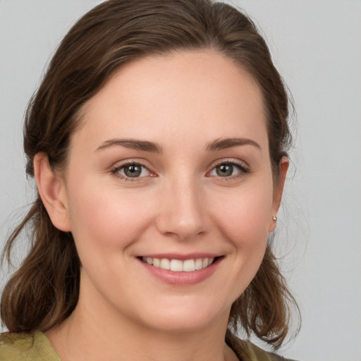 Joyful white young-adult female with medium  brown hair and grey eyes