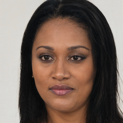 Joyful black young-adult female with long  black hair and brown eyes