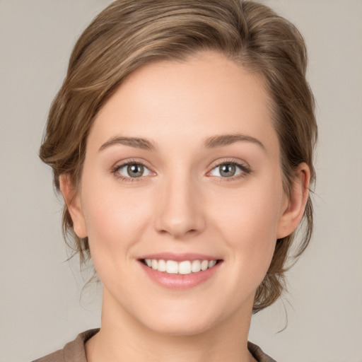 Joyful white young-adult female with medium  brown hair and green eyes