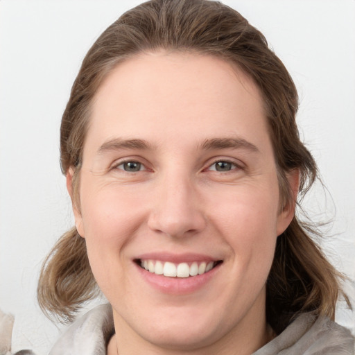 Joyful white young-adult female with medium  brown hair and blue eyes