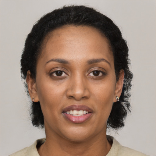 Joyful black adult female with short  black hair and brown eyes