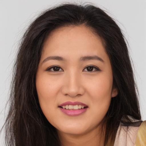 Joyful asian young-adult female with long  brown hair and brown eyes