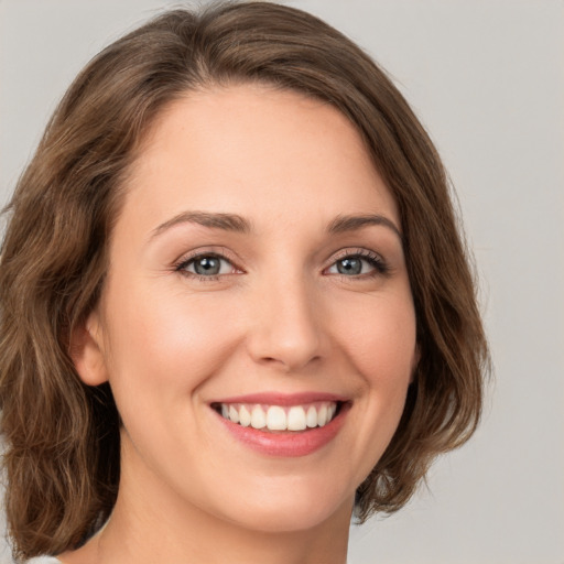 Joyful white young-adult female with medium  brown hair and green eyes