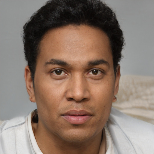 Joyful latino young-adult male with short  brown hair and brown eyes