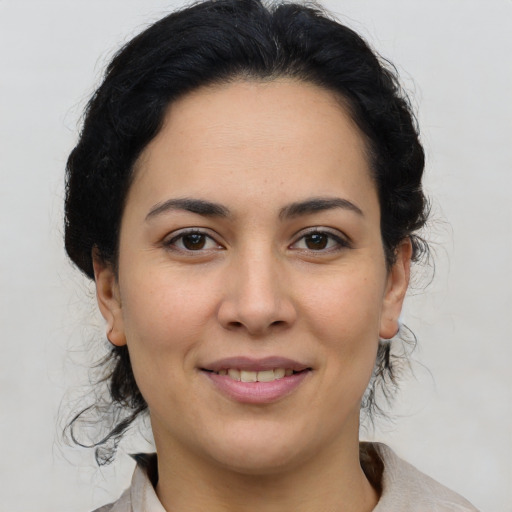 Joyful latino young-adult female with medium  brown hair and brown eyes