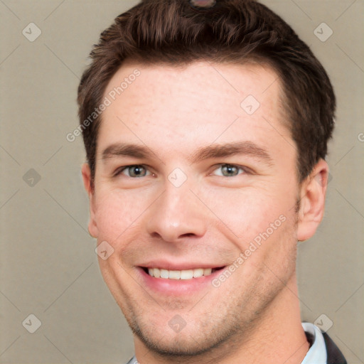 Joyful white young-adult male with short  brown hair and grey eyes