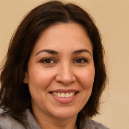 Joyful white adult female with long  brown hair and brown eyes