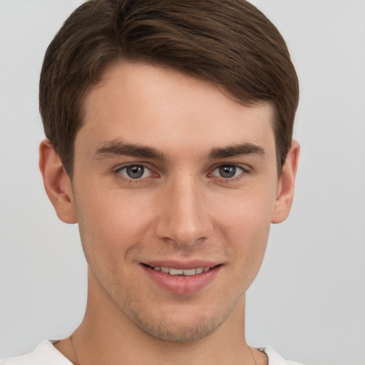 Joyful white young-adult male with short  brown hair and grey eyes