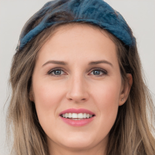 Joyful white young-adult female with long  brown hair and blue eyes