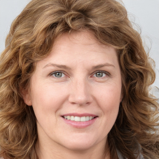 Joyful white adult female with medium  brown hair and green eyes