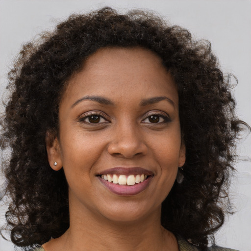Joyful black young-adult female with short  brown hair and brown eyes
