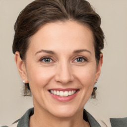 Joyful white young-adult female with medium  brown hair and grey eyes