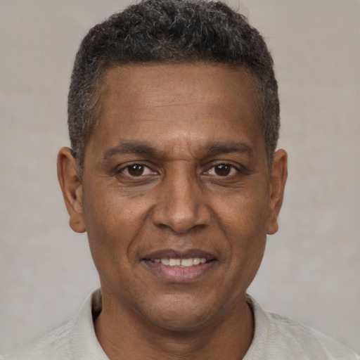 Joyful black adult male with short  brown hair and brown eyes