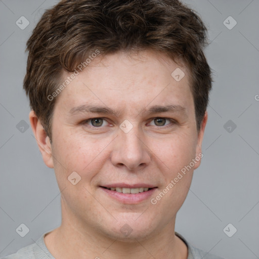 Joyful white young-adult male with short  brown hair and grey eyes