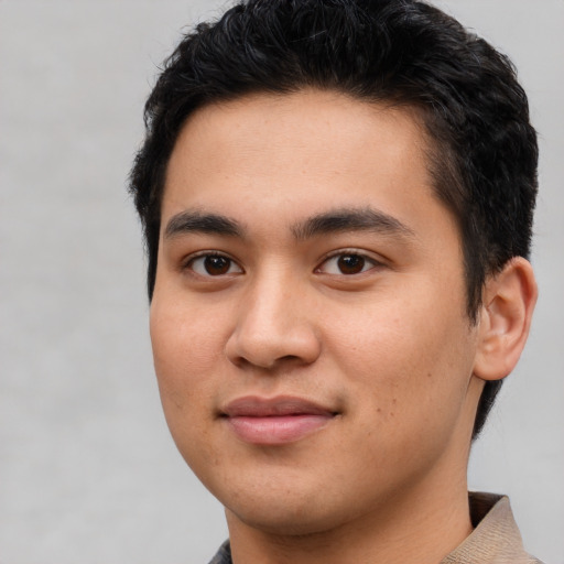 Joyful latino young-adult male with short  black hair and brown eyes