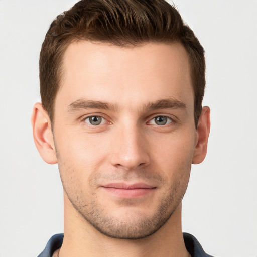 Joyful white young-adult male with short  brown hair and grey eyes