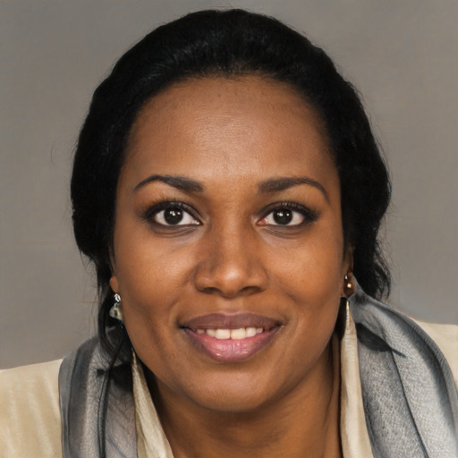 Joyful black young-adult female with long  black hair and brown eyes