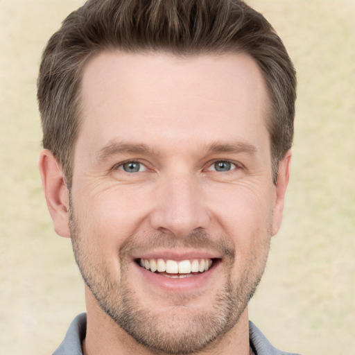 Joyful white adult male with short  brown hair and grey eyes