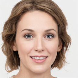 Joyful white young-adult female with medium  brown hair and green eyes