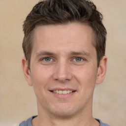 Joyful white young-adult male with short  brown hair and grey eyes