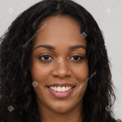 Joyful black young-adult female with long  brown hair and brown eyes