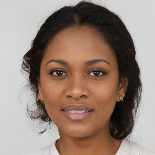 Joyful black young-adult female with long  brown hair and brown eyes