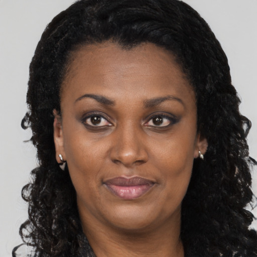 Joyful black young-adult female with long  brown hair and brown eyes