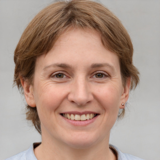 Joyful white adult female with medium  brown hair and grey eyes