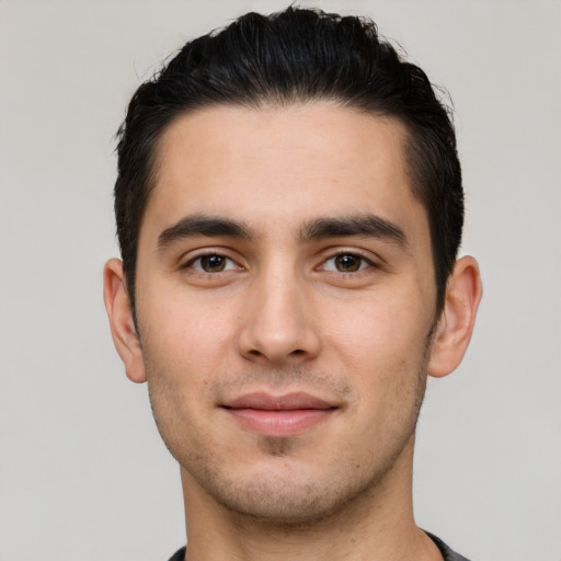 Joyful white young-adult male with short  black hair and brown eyes