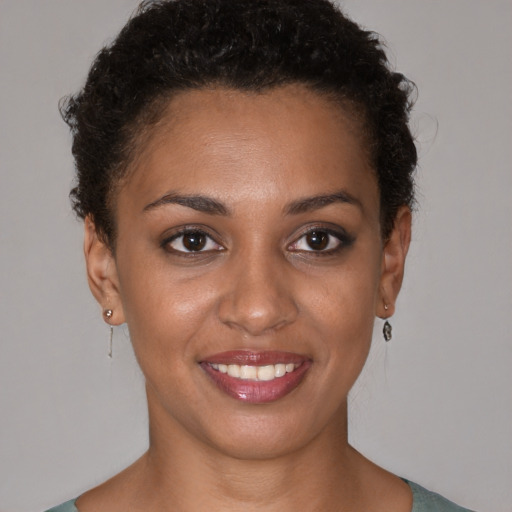 Joyful black young-adult female with short  brown hair and brown eyes