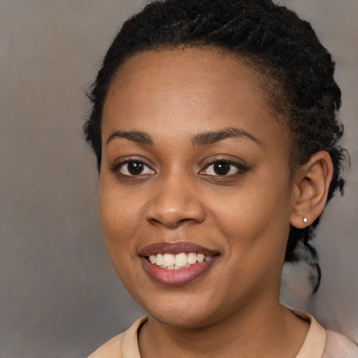 Joyful black young-adult female with short  brown hair and brown eyes