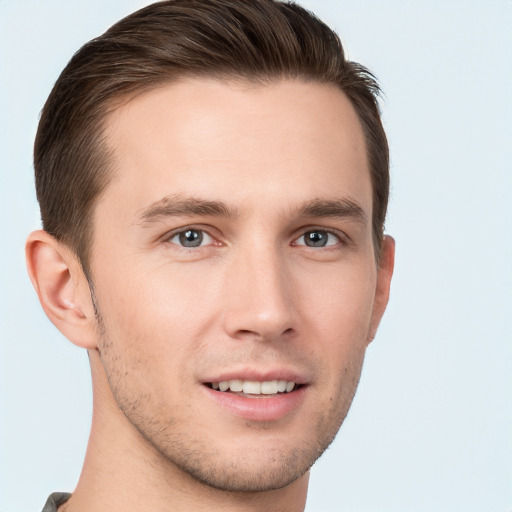 Joyful white young-adult male with short  brown hair and grey eyes