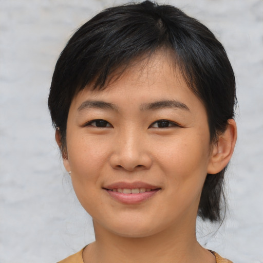 Joyful asian young-adult female with medium  brown hair and brown eyes