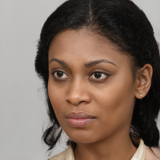 Joyful black young-adult female with long  black hair and brown eyes