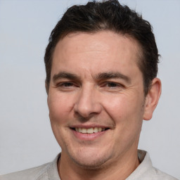 Joyful white adult male with short  brown hair and brown eyes