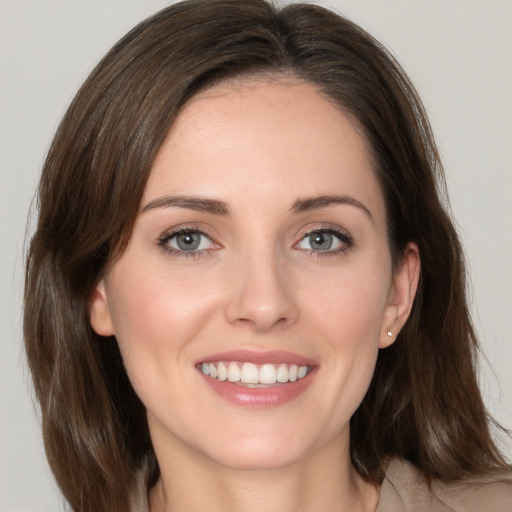 Joyful white young-adult female with medium  brown hair and grey eyes