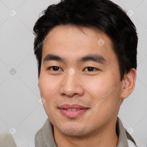 Joyful asian young-adult male with short  brown hair and brown eyes